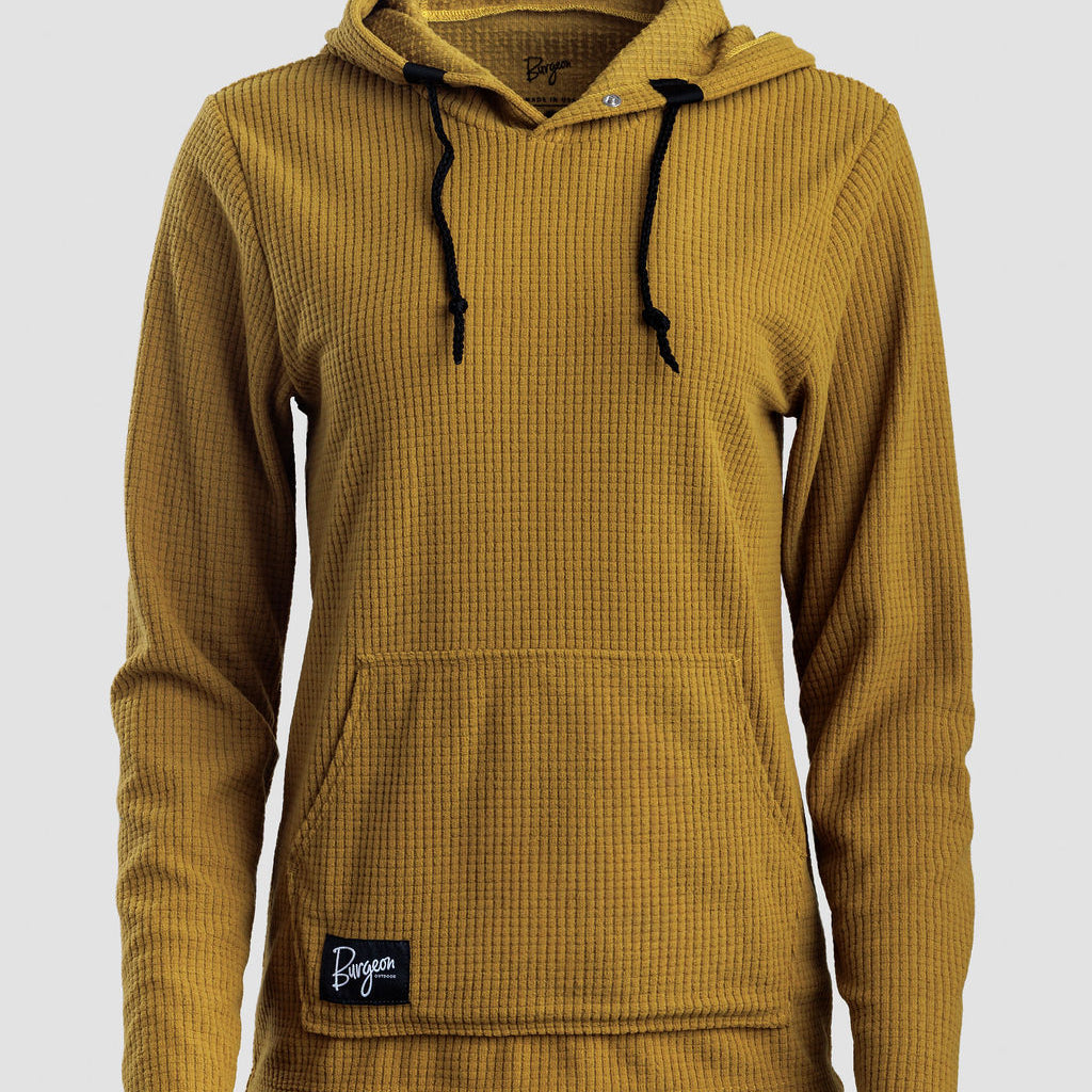 A women's mustard yellow Highlander Hoodie with black drawstrings and a small black 'Doge' brand patch on the front pocket, shown against a light gray background.