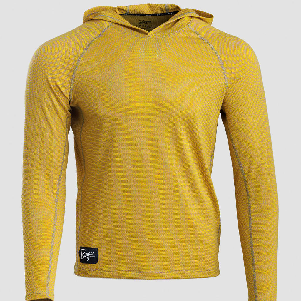 A yellow long-sleeve Sunseeker Hoodie with gray contrast stitching and a small black brand patch near the bottom left hem, shown on a light gray background.