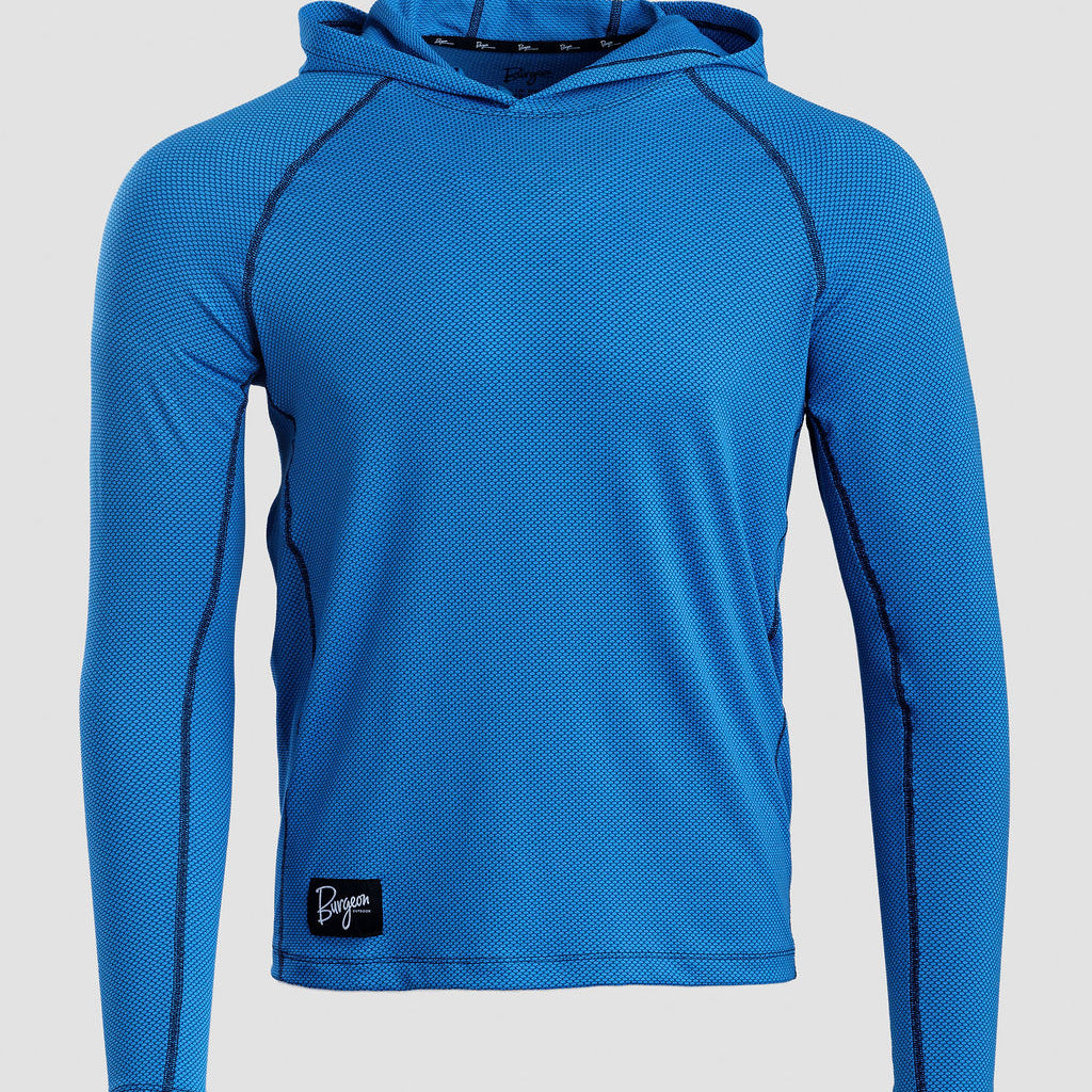 A bright blue long-sleeve Sunseeker Hoodie with black contrast stitching and a small black logo patch on the bottom left, displayed on a neutral light gray background.