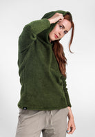 A woman wearing a Alpha 120 Hoodie  and light beige pants, posing against a plain white studio background.
