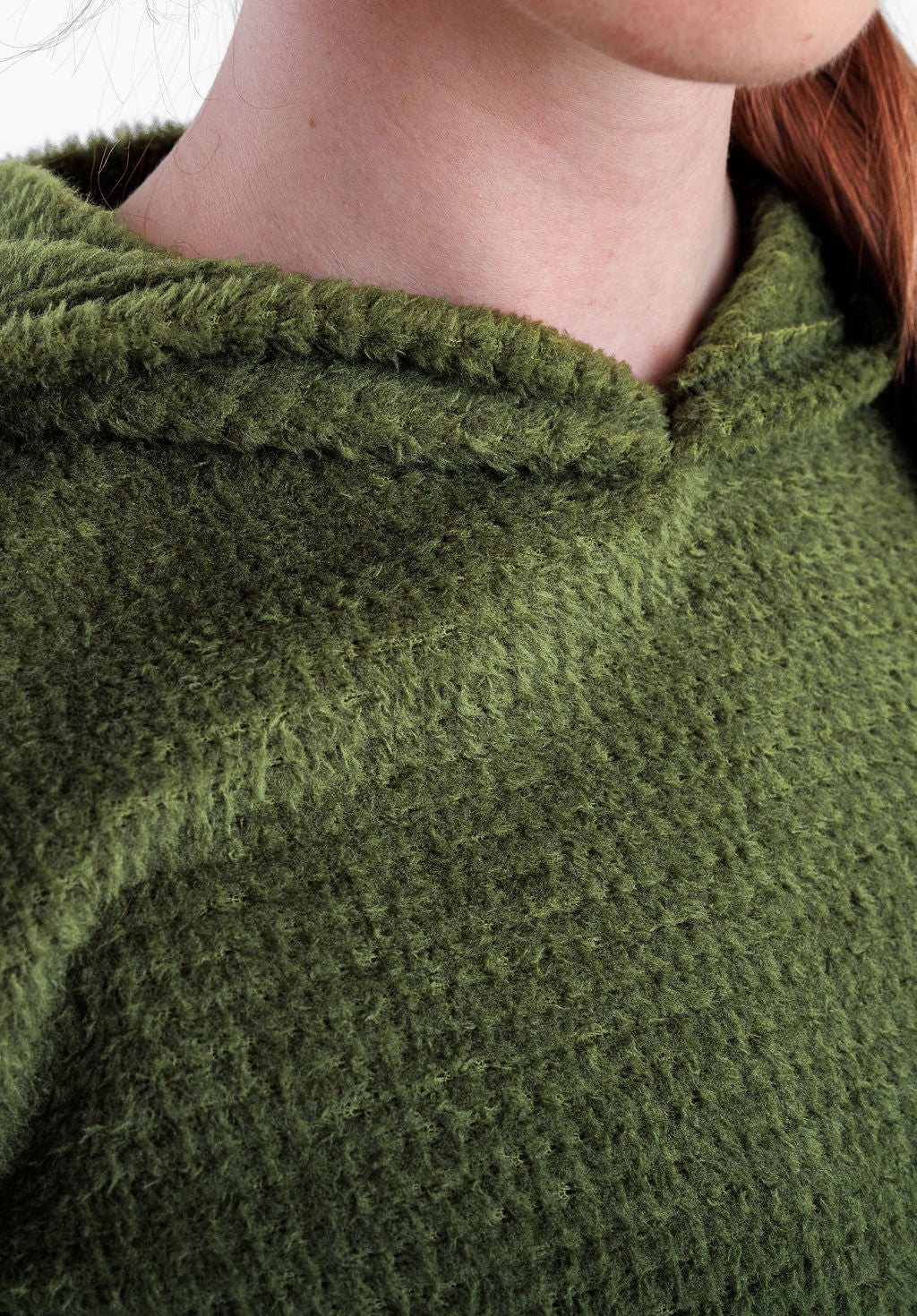 Close-up of a person wearing a Alpha 120 Hoodie , showing the neck, collar, and part of the shoulder against a light neutral background.