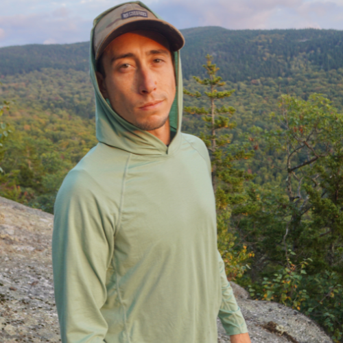 Male hiker wearing the Flume Hoodie in 'Mantis Green.'