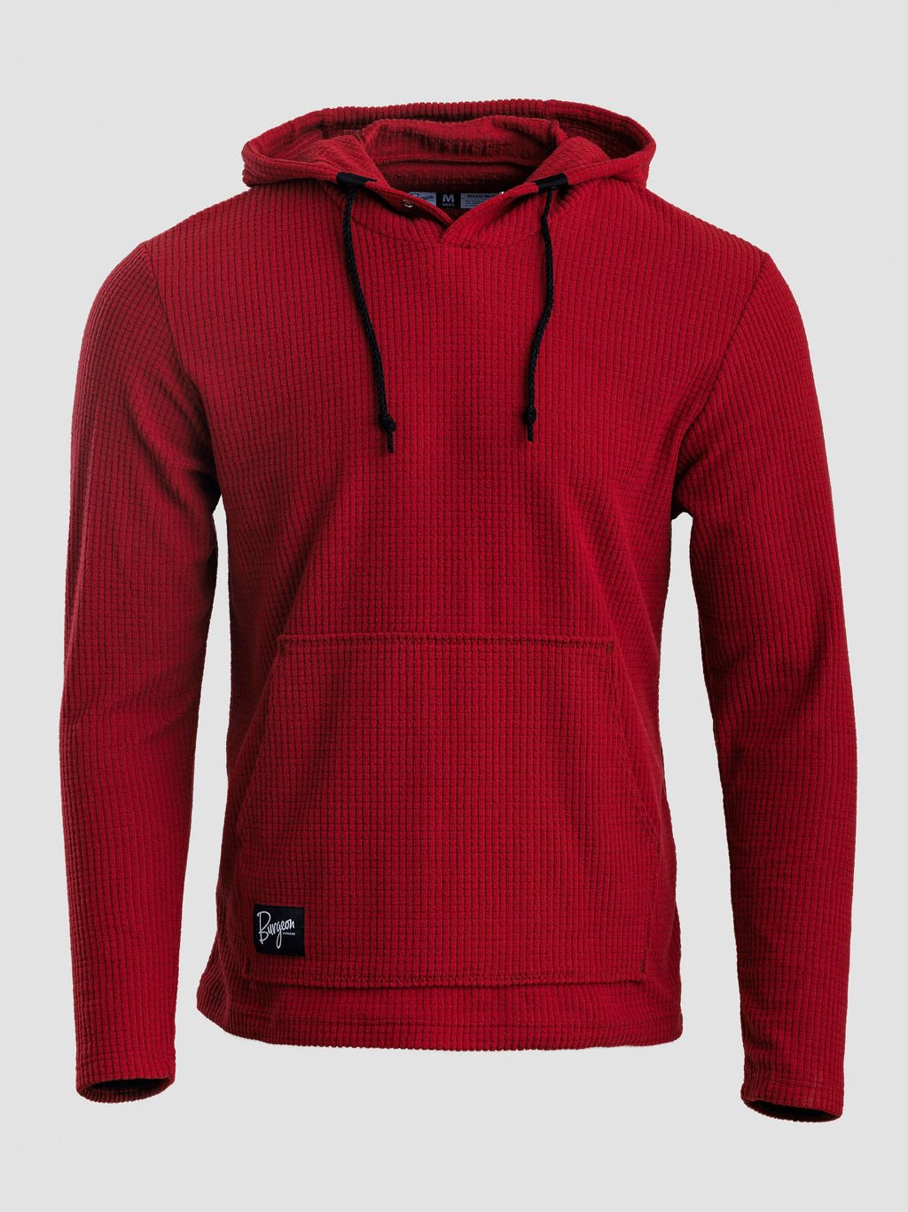 A red Highlander hoodie with black drawstrings and a small black brand patch near the bottom left hem, shown against a light gray background.