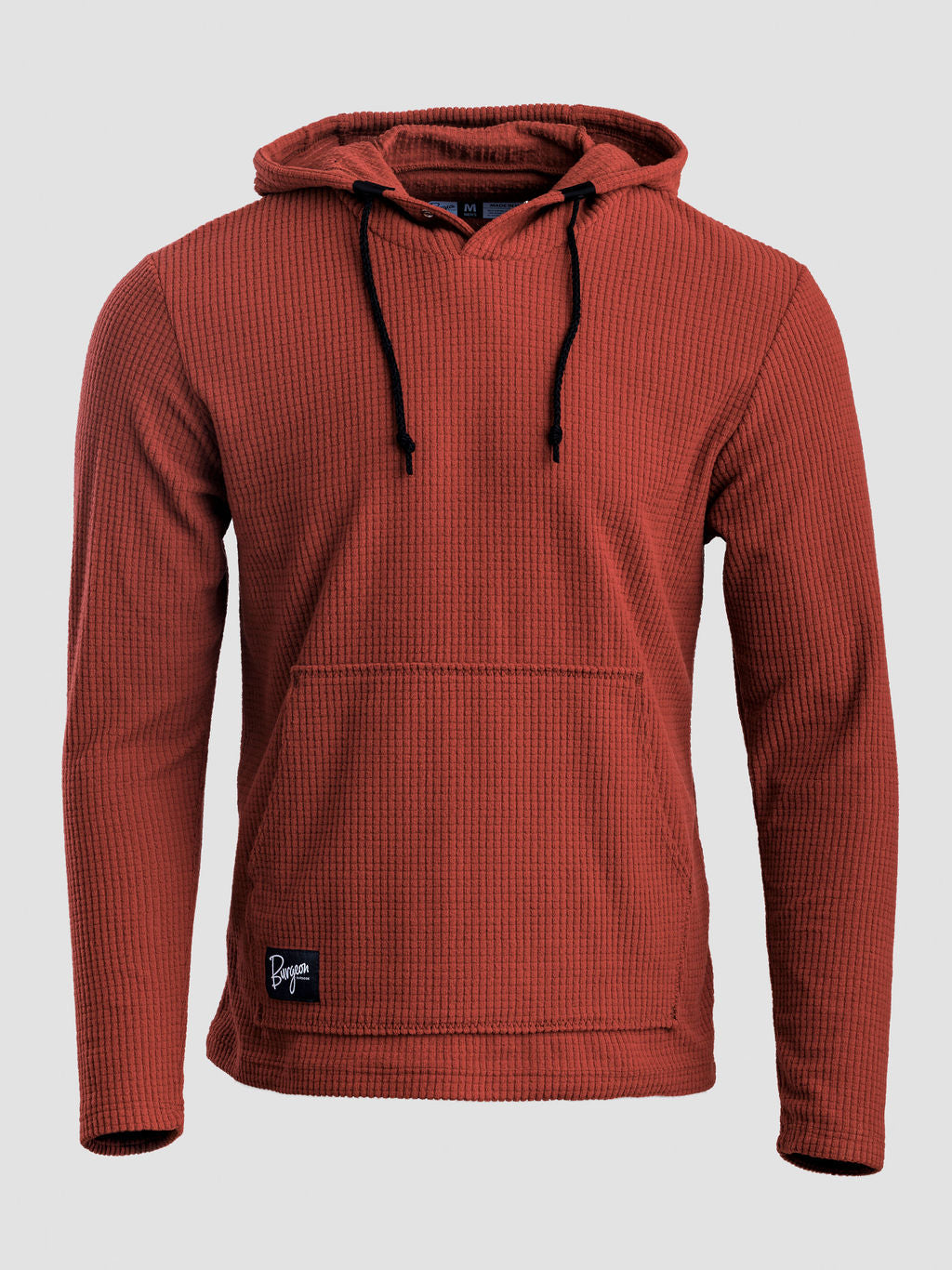 A rust-colored Highlander hoodie with black drawstrings and a small black brand patch on the lower left hem, shown against a light gray background.