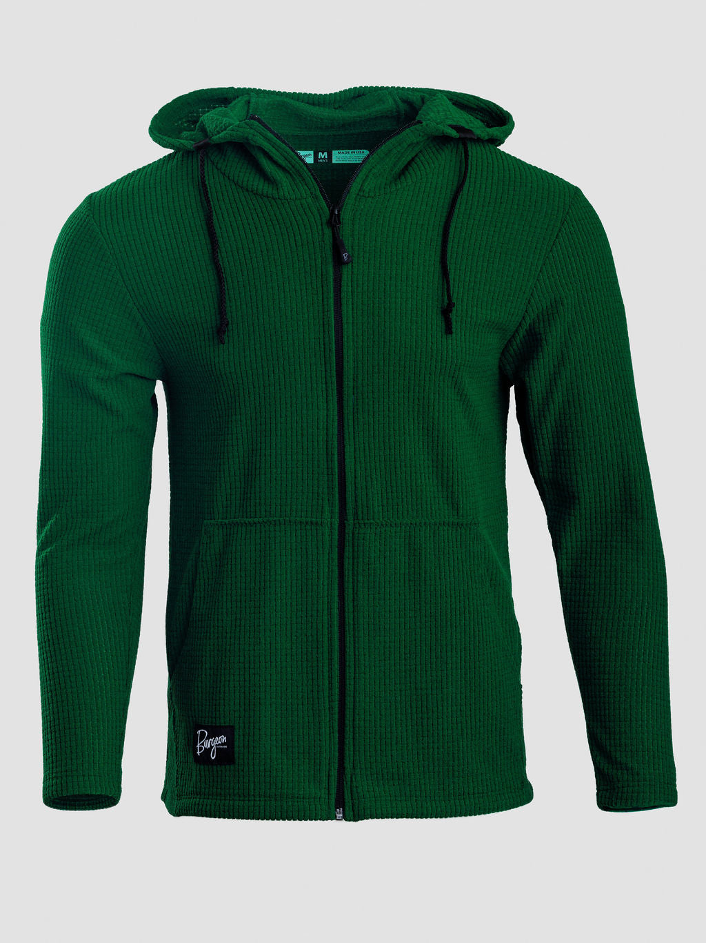 A dark green waffle-knit zip-up hoodie with a drawstring hood and a small black brand patch on the lower left hem, shown against a light gray background.