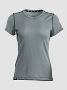 A women's short-sleeve athletic t-shirt in a solid medium gray color, featuring a crew neck and subtle dark gray contrast stitching details, shown against a light gray background.