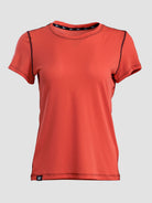A women's short-sleeve athletic t-shirt in a vibrant orange-red color, featuring black contrast stitching along the shoulders and neckline, displayed against a solid light gray background.