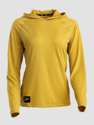 A yellow long-sleeve sun hoodie with a textured mesh fabric, shown on a neutral light gray background. It features a black brand patch near the bottom hem and a black logo strip on the inside of the hood.