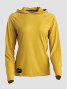A yellow long-sleeve sun hoodie with a textured mesh fabric, shown on a neutral light gray background. It features a black brand patch near the bottom hem and a black logo strip on the inside of the hood.
