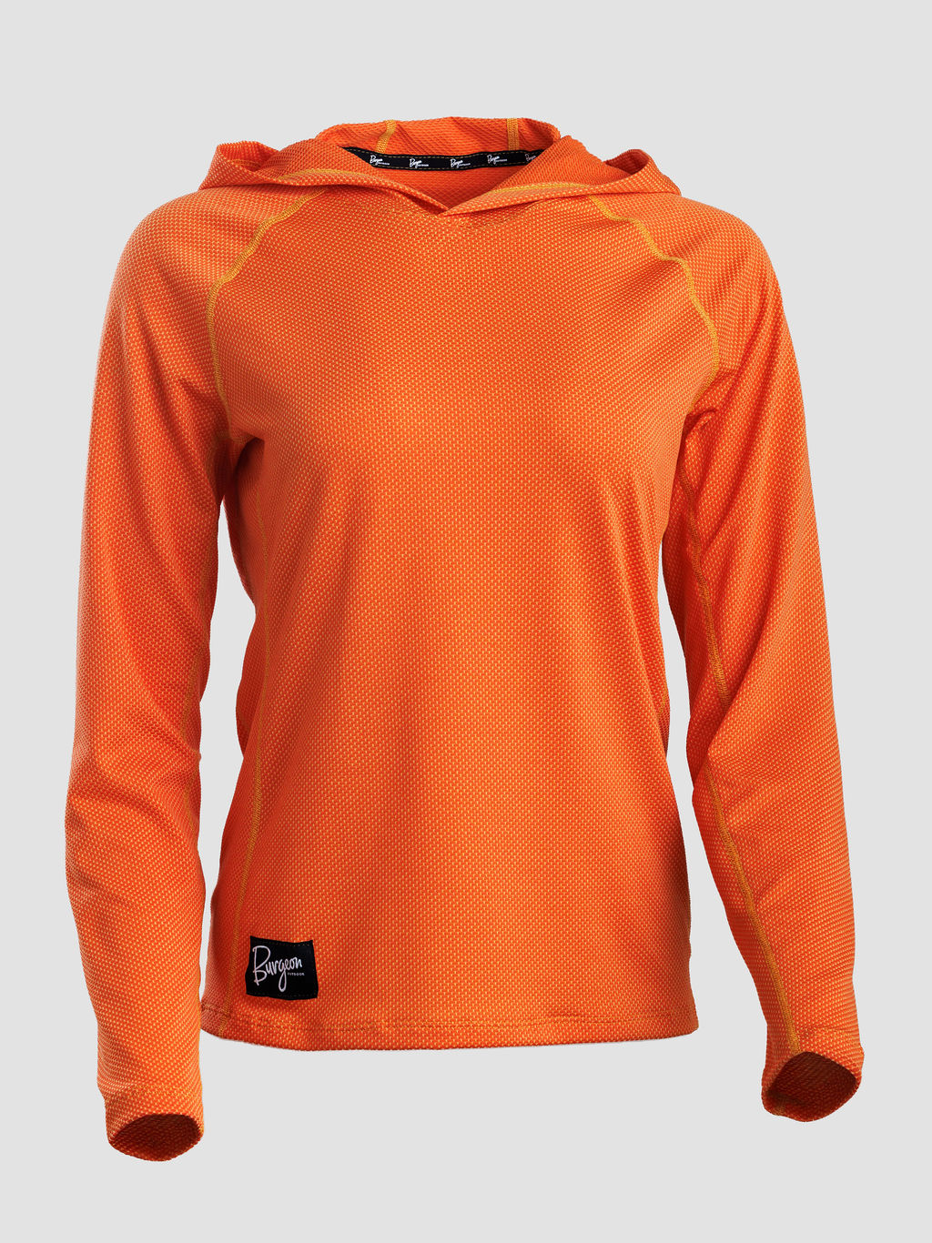 An orange long-sleeve sun hoodie with a textured mesh fabric, raglan sleeves, and a small black logo patch on the lower left hem, shown against a light gray background.