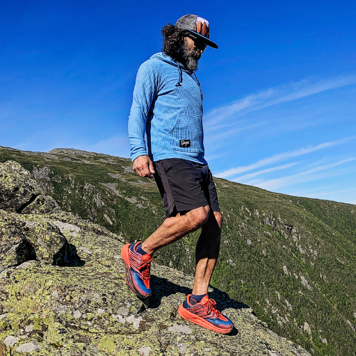 Men's Hiker wearing Iceberg Highlander Hoodie atop mountain